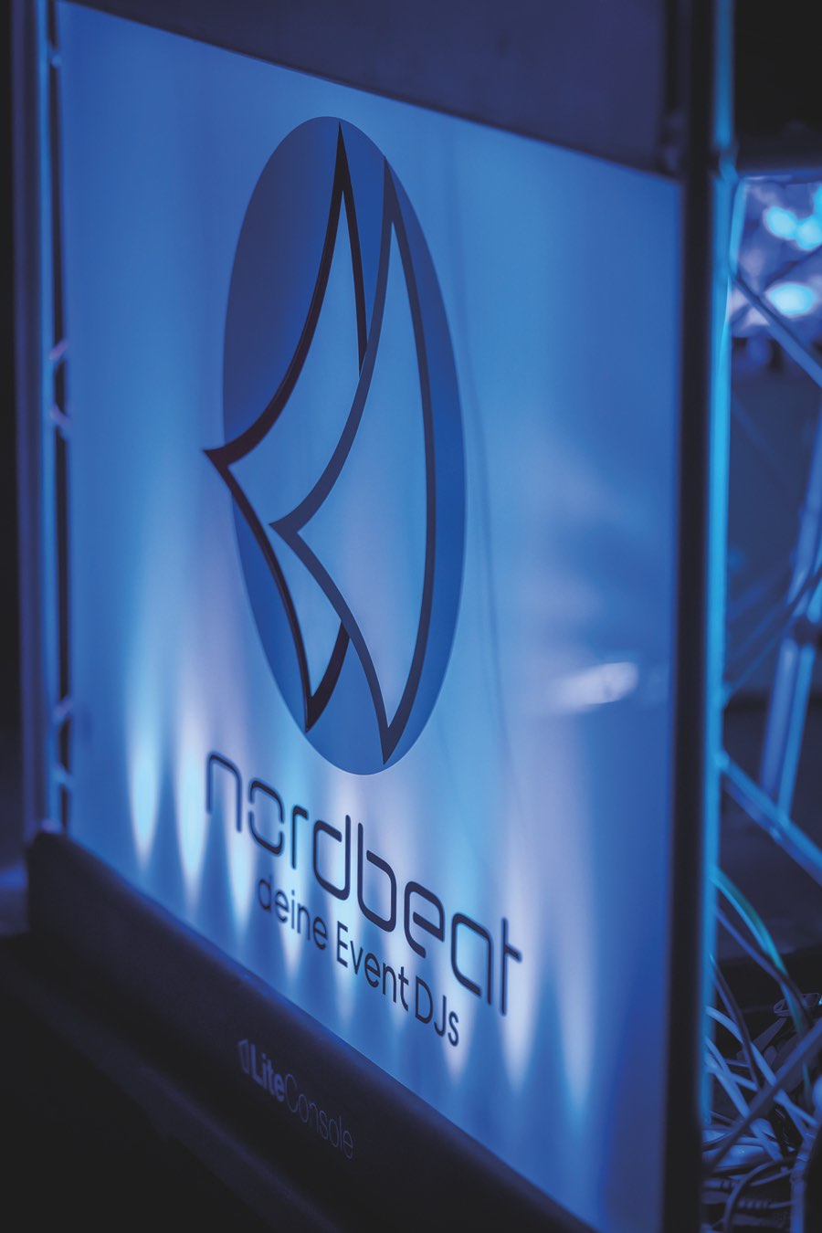 Nordbeat DJ-Booth mit beleuchtetem Logo in blauem Licht