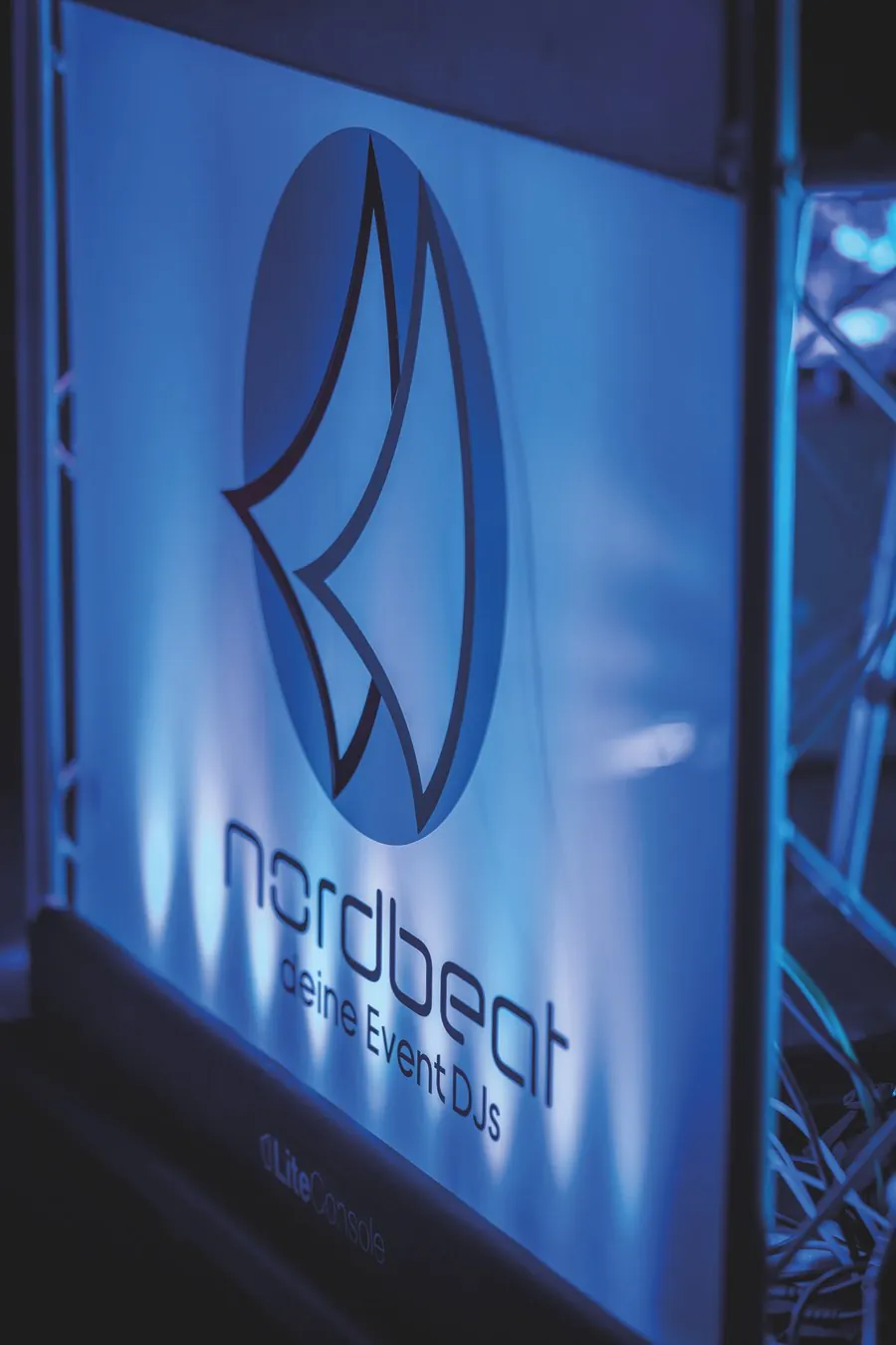 Nordbeat DJ-Booth mit beleuchtetem Logo in blauem Licht